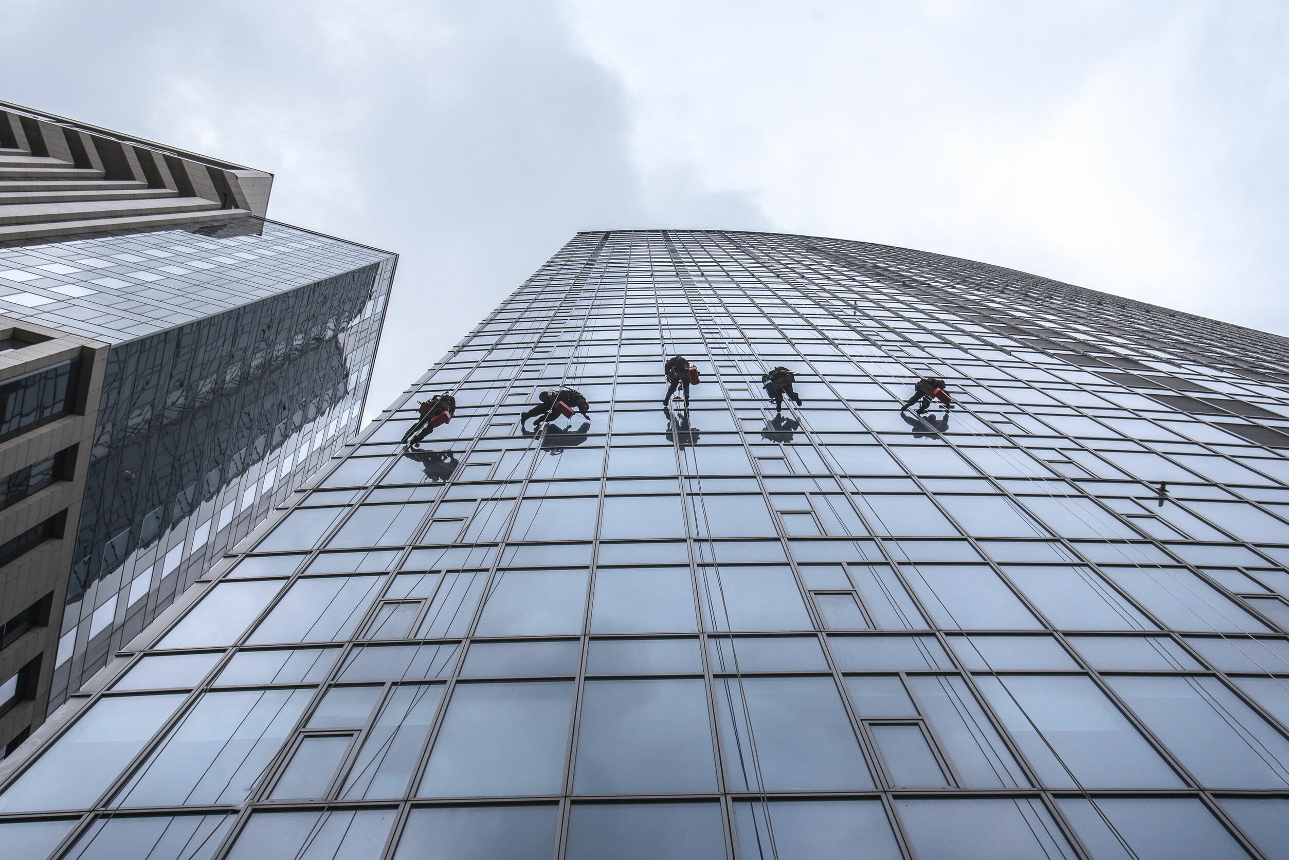 Window washers cleaning the glass facade of a skyscraper, high risk work. Gulliver tower in Kiev, Ukraine